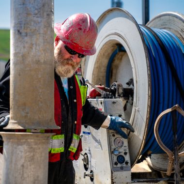 Man pressure washing a pipe